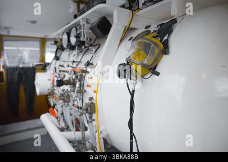 Vista laterale della camera iperbarica con dettaglio di valvole e tubi Foto Stock