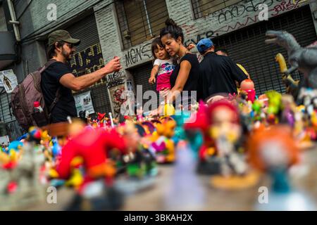 Una donna uruguaiana, insieme a sua figlia, sceglie un giocattolo in una bancarella del mercato di strada Tristán Narvaja a Montevideo, Uruguay. Foto Stock