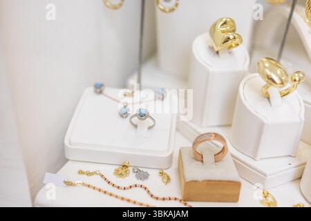 Anelli di design colorati in un'elegante vetrina. Espressione della moda, gioielli moderni e accessori artistici. Foto Stock