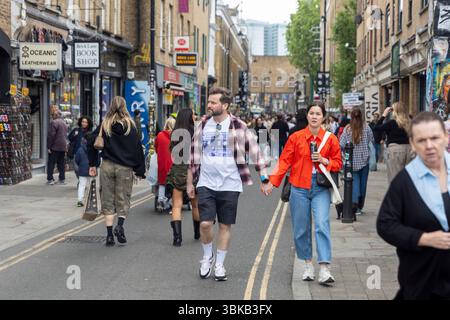 Londra, Regno Unito, 15 maggio 2025, coppia che tiene per mano il mercato di Brick Lane a Londra Foto Stock