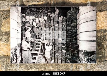 Una vecchia cartolina del museo Four des Casseaux di Limoges mostra una foto di Paul Colmar: Gli operai che confezionano il forno per la seconda cottura, gli stampi di argilla pesante, ciascuno contenente un bianco di porcellana, erano impilati metri di altezza nel grande forno. Rue Donzelot, Limoges, Nouvelle-Aquitaine, Francia Foto Stock