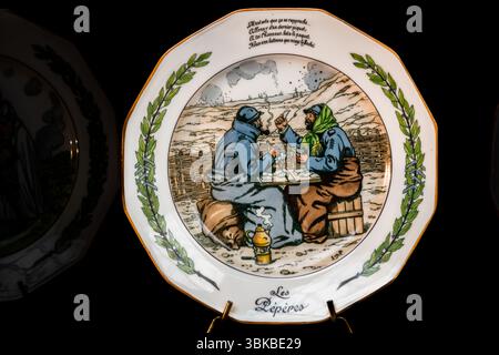 Il piatto di porcellana patriottico "Les Pépères" mostra due soldati francesi barbuti in mantelli blu ed elmetti che giocano a carte a un tavolo di assi in una trincea. In inglese: "The Grandpas". Uno fuma una pipa, il suo compagno indossa una sciarpa verde sopra l'elmetto. Sono seduti su un sacco e una botte di legno, e una caffettiera è posizionata su un piccolo fornello davanti a loro. I soldati usavano "pépères" per gli uomini più anziani dell'esercito territoriale, che avevano più di 35 anni al momento della mobilitazione. È esposta al Musée National Adrien Dubouché in Place Winston Churchill a Limoges, Haute-Vienne, Nouvelle-Aquitaine, Francia. La porcellana patriottica Foto Stock