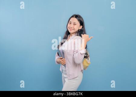 Una donna tiene in mano un tablet e lo indica. Lei sorride ed è felice Foto Stock