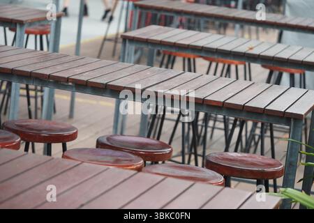 Posti a sedere urbani all'aperto con tavoli e sgabelli Foto Stock