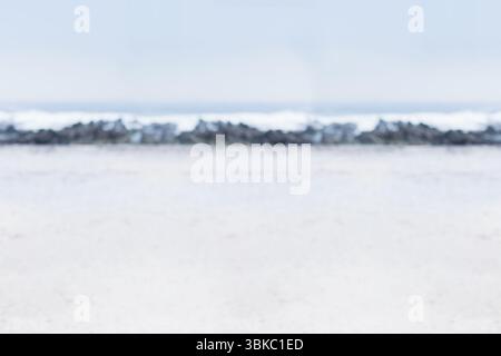 Design piatto che mostra la scogliera che si estende su una spiaggia di sabbia chiara con onde che si infrangono dolcemente Foto Stock