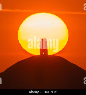 Glastonbury, Somerset, Regno Unito. 20 giugno 2025. Meteo nel Regno Unito. Una spettacolare alba mentre il sole sorge da dietro la St Michael's Tower a Glastonbury Tor nel Somerset in una calda mattina estiva durante l'ondata di caldo. Crediti fotografici: Graham Hunt/Alamy Live News Foto Stock