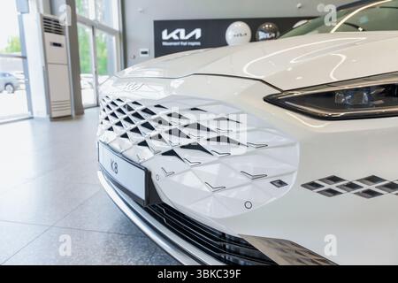 Almaty, Kazakistan - 11 giugno 2025: La parte anteriore dell'auto bianca Kia K8. Casa automobilistica coreana Foto Stock