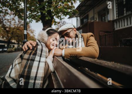Una coppia felice gode di un'accogliente giornata autunnale all'aperto nel parco cittadino Foto Stock