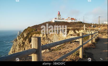 Splendido panorama con il faro di farol nell'Oceano Atlantico a Cape Cabo da Roca, Portogallo. Il punto più occidentale d'Europa, marzo 2023 Foto Stock