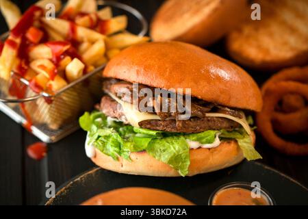 Hamburger al barbecue con pepe nero e jalapenos servito con patatine fritte. Foto Stock