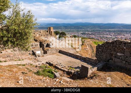 Guardando in basso dall'acropoli superiore di Pergamo sulla collina di Kale Dagi in Turchia, il teatro ellenistico, le antiche strutture in pietra e la città di Berg Foto Stock