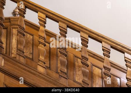 Elegante primo piano di una scala in legno splendidamente intagliata che mostra dettagli intricati e maestria artigianale, caratterizzata da un'elegante e ben curata Foto Stock