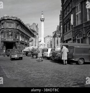 1960s, Historical, Billingsgate Fish Market, Ford Cortina, City of London, Inghilterra, Regno Unito. Il Monumento al grande incendio di Londra, più comunemente noto semplicemente come Monumento, è una colonna dorica scanalata. Per commemorare il grande incendio di Londra, si trova all'incrocio tra Monument Street e Fish Street Hill. Billingsgate, ex mercato di Londra (chiuso nel 1982). Si trovava nella City di Londra all'estremità nord del London Bridge accanto al Monumento, che commemora lo scoppio del grande incendio del settembre 1666. Foto Stock