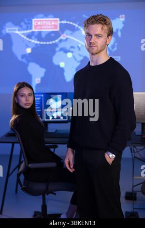 Analista di Cybersecurity maschile e il suo team del Cyber Security Operation Center SOC che gestisce le minacce. Foto Stock