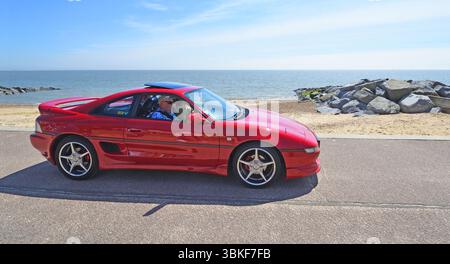 La classica Toyota rossa MR2 è guidata lungo il lungomare Foto Stock
