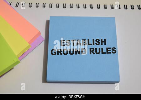 Concetto di stabilire regole di base scrivere su note adesive isolate su un tavolo di legno. Foto Stock