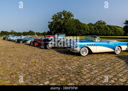 Auto d'epoca si incontrano sulla strada acciottolata di fronte alla Corderie Royale a Rochefort: Diverse auto americane degli anni '1950 e '1960 sono schierate, tra cui, in primo piano, una Buick cabriolet di fascia media (c. 1955) in blu e bianco, nonché un modello Chevrolet nero con pick-Cab dei primi anni '1950 Quai Joseph Bellot, Rochefort, Charente-Maritime, Nouvelle-Aquitaine, Francia Foto Stock