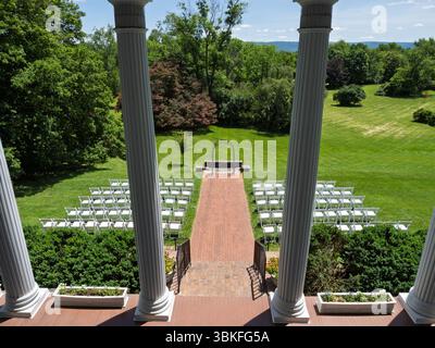 Elegante allestimento all'aperto per cerimonie nuziali con sedie bianche e navata sul vasto prato della storica Rosemont, Berryville, Virginia. Foto Stock