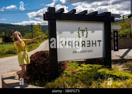Una donna indica il cartello al Therapy Vinyard di Okanagan, British Columbia, Canada Foto Stock