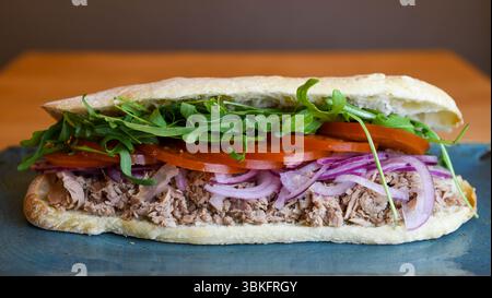 Panino gourmet con tonno e condimenti freschi sul pane artigianale Foto Stock