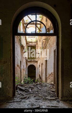 Edificio abbandonato interno con rovine e vegetazione sovrastata a Tskaltubo, Georgia Foto Stock
