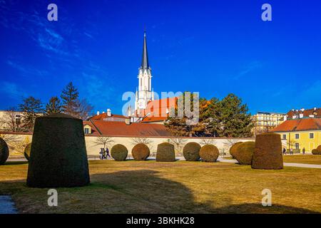 Giardino del Palazzo di Schönbrunn e Chiesa cattolica Hietzing (nascita di Maria), Vienna, Austria Foto Stock