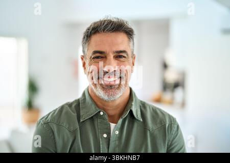 Felice anziano di mezza età in piedi a casa. Primo piano verticale. Foto Stock