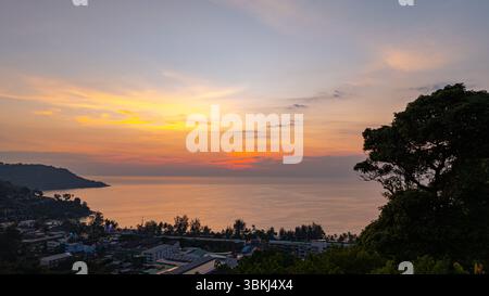 Una vista aerea mozzafiato di Kata Beach a Phuket, Thailandia, catturata durante il tramonto. L'immagine mostra la costa, le piccole isole, il lussureggiante hil verde Foto Stock