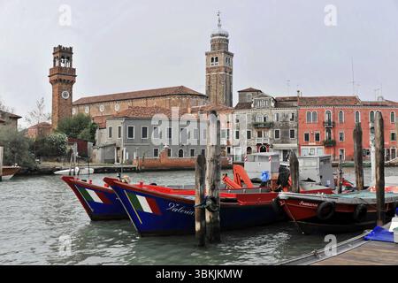 Venezia, Veneto, Italia, Europa, barche colorate con bandiere italiane accanto a un canale di Venezia, con una torre sullo sfondo, Europa Foto Stock