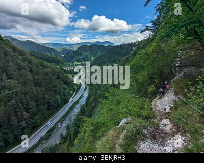 Scalatore che sale per Koschlak Klettersteig tramite la ferrata nelle Alpi austriache su pareti rocciose sicure. Foto Stock