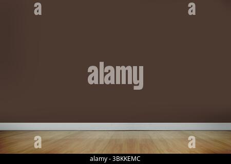 Le camere Vacant presentano un design piatto con pareti marroni lisce, pavimento in legno chiaro e base bianca Foto Stock