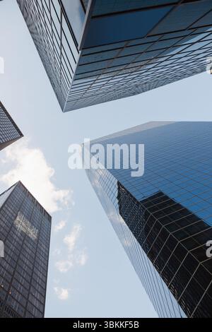 I grattacieli in vetro riflettente convergono verso l'alto in una città dal design piatto, mostrando una griglia in acciaio specchiato Foto Stock
