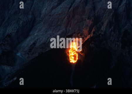 Lermoos, Austria. Lermoos, Austria. 21 giugno 2025. Numerosi incendi possono essere visti sulle montagne nella Tiroler Zugspitz Arena nel bacino della valle di Ehrwald Lermoos e Biberwier in Tirol (Austria) il 21.06.2025 per il solstizio d'estate. L'immagine mostra i monti Wetterstein con il versante tirolese dello Zugspitze, su cui i fuochi formano una marmotta. Ogni anno, nella regione si festeggia il giorno più lungo e la notte più breve con spettacolari motivi di fuoco. All'imbrunire, il cosiddetto "Bergfeurer" accende gli incendi di mezza estate, che poi bruciano nella notte. Credito: dpa Picture Alliance/Alamy Live News Foto Stock