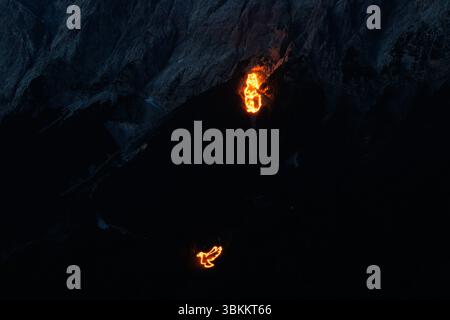 Lermoos, Austria. 21 giugno 2025, Austria, Lermoos: Numerosi incendi si possono vedere sulle montagne nella Tirolo Zugspitz Arena nel bacino Ehrwald Lermoos e Biberwier nel Tirolo (Austria) il 21.06.2025 per il solstizio d'estate. L'immagine mostra i monti Wetterstein con il versante tirolese dello Zugspitze, su cui i fuochi formano una marmotta e una colomba di pace. Ogni anno, nella regione si festeggia il giorno più lungo e la notte più breve con spettacolari motivi di fuoco. All'imbrunire, il cosiddetto "Bergfeurer" accende gli incendi di mezza estate, che poi bruciano nella notte. Credito: dpa Picture allian Foto Stock