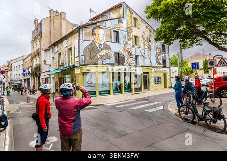 I turisti in bicicletta a Angoulême di fronte al murale "il mondo di René Goscinny", che raffigura il fumettista con i suoi personaggi più famosi come Asterix, Lucky Luke e Petit Nicolas. Un gruppo di ciclisti si ferma per guardare e fotografare un murale che adorna la facciata di un edificio. Il murale raffigura scene dei fumetti di René Goscinny, un famoso autore francese di fumetti nato a Angoulême. La scena cattura l'atmosfera vivace della città, famosa per la sua arte comica. Angoulême è riconosciuta come città creativa dell'UNESCO nella categoria della letteratura dal 2019. Rue Ren Foto Stock