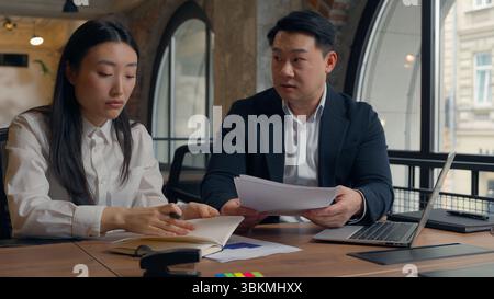 Arrabbiato folle furioso tossico irritato uomo d'affari coreano asiatico capo capo capo CEO documenti contrattuali che parlano con cinese giapponese Foto Stock