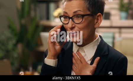 Ritratto in ufficio felice emotivo parlare stupito sorpreso grigio dai capelli anziani anziani anziani anziani anziani anziani anziani donna d'affari donna d'affari Foto Stock