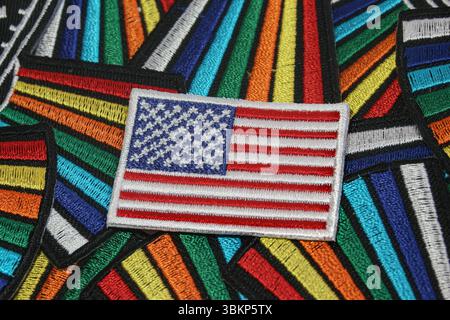 Bandiera americana fatta a mano su sfondo in tessuto arcobaleno simboleggia la diversità culturale e l'inclusione negli Stati Uniti d'America. Foto Stock