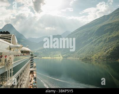 Geiranger, Norvegia - 08.09.2024: La nave da crociera naviga alla luce del sole sul Geirangerfjord in Norvegia e verso la città di Geiranger. Foto Stock