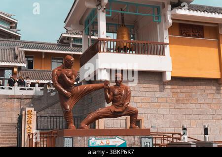Viaggia, Cina, tradizione buddista e le statue di Kung fu Shaolin Kung fu di fronte alle porte del teatro dello spettacolo Kung fu in He Shaolin Foto Stock
