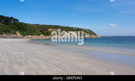 Spiaggia sabbiosa di Corréjou a Camaret-sur-Mer, Bretagna, con Grand Gouin Point in lontananza. Cielo azzurro, mare calmo e bassa marea. Tranquilla lan costiera Foto Stock