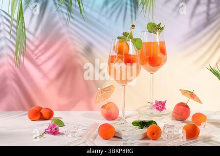 Natura morta moderna con frutta. Cocktail reale alla limonata con pesca, albicocca, mojito con tequila, gin, rum, ghiaccio e menta fresca, bar e party concept, Foto Stock