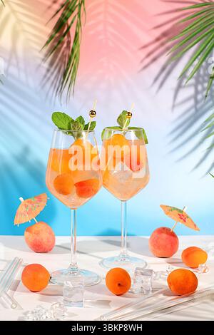 Natura morta moderna con frutta. Cocktail reale alla limonata con pesca, albicocca, mojito con tequila, gin, rum, ghiaccio e menta fresca, bar e party concept, Foto Stock
