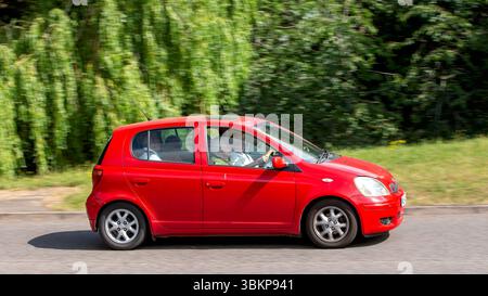 Milton Keynes,Bucks,UK - 22 giugno 2025: 2004 auto Toyota Yaris rossa che guida su una strada britannica Foto Stock
