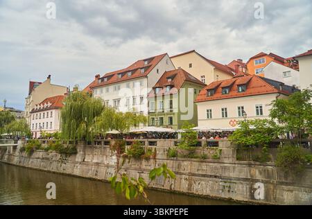 Slovenia, Lubiana - 23 settembre 2022: Scopri gli affascinanti e pittoreschi edifici lungo il fiume situati a Lubiana, Slovenia Foto Stock