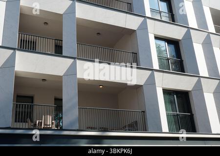 Facciata di un blocco di appartamenti a Bucarest, con balconi e finestre Foto Stock