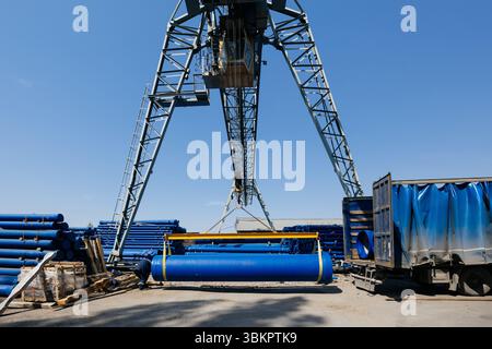 Caricamento del tubo in ghisa nel camion per il trasporto con carroponte. Foto Stock