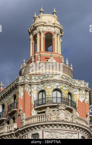 Dettaglio della parte superiore decorata dell'edificio del Banco de Valencia (edificio del Banco de Valencia), del 1942, con facciata color arancio e ceramica Foto Stock