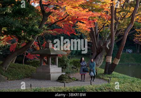 I visitatori della lanterna di pietra Igyo (異形灯籠) ishidoro a Koishikawa Korakuen (小石川後楽園), uno dei più antichi e più bei giardini paesaggistici giapponesi di Tokyo, il Giappone Foto Stock
