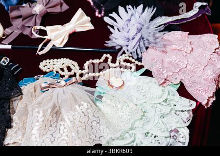 Piatto di accessori in stile vintage, tra cui pizzi, archi, perle finte e fiori decorativi su sfondo di velluto. Foto Stock